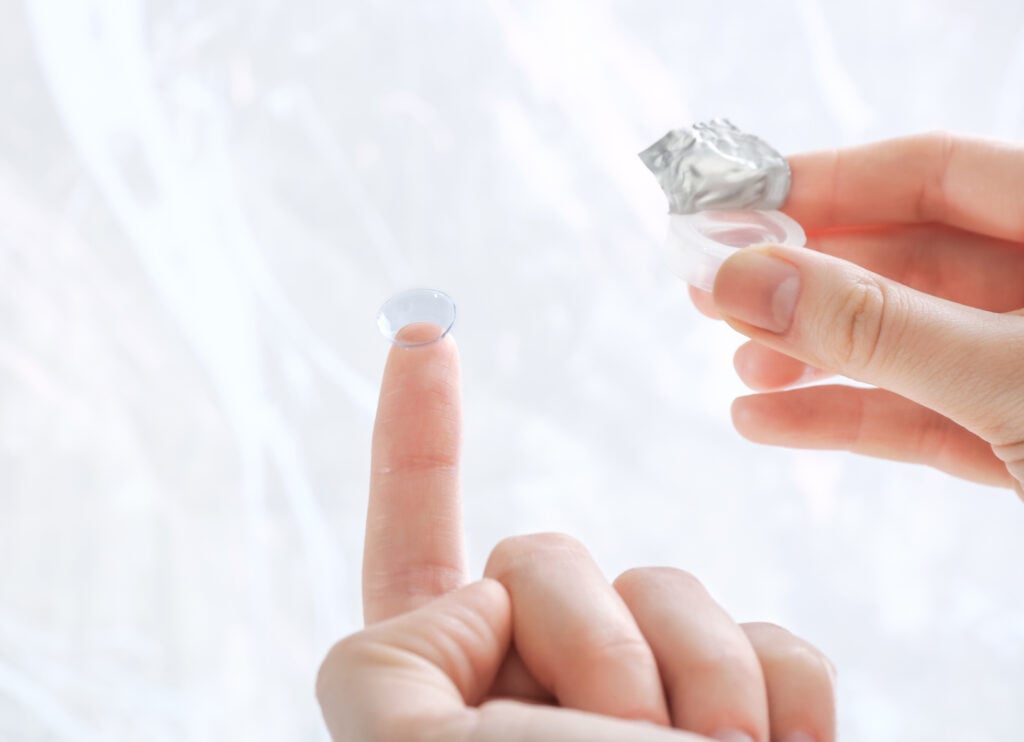 Gas Permeable Contact Lenses (RGP or GP) 2 Gas permeable contact lenses being held by woman outside of photo