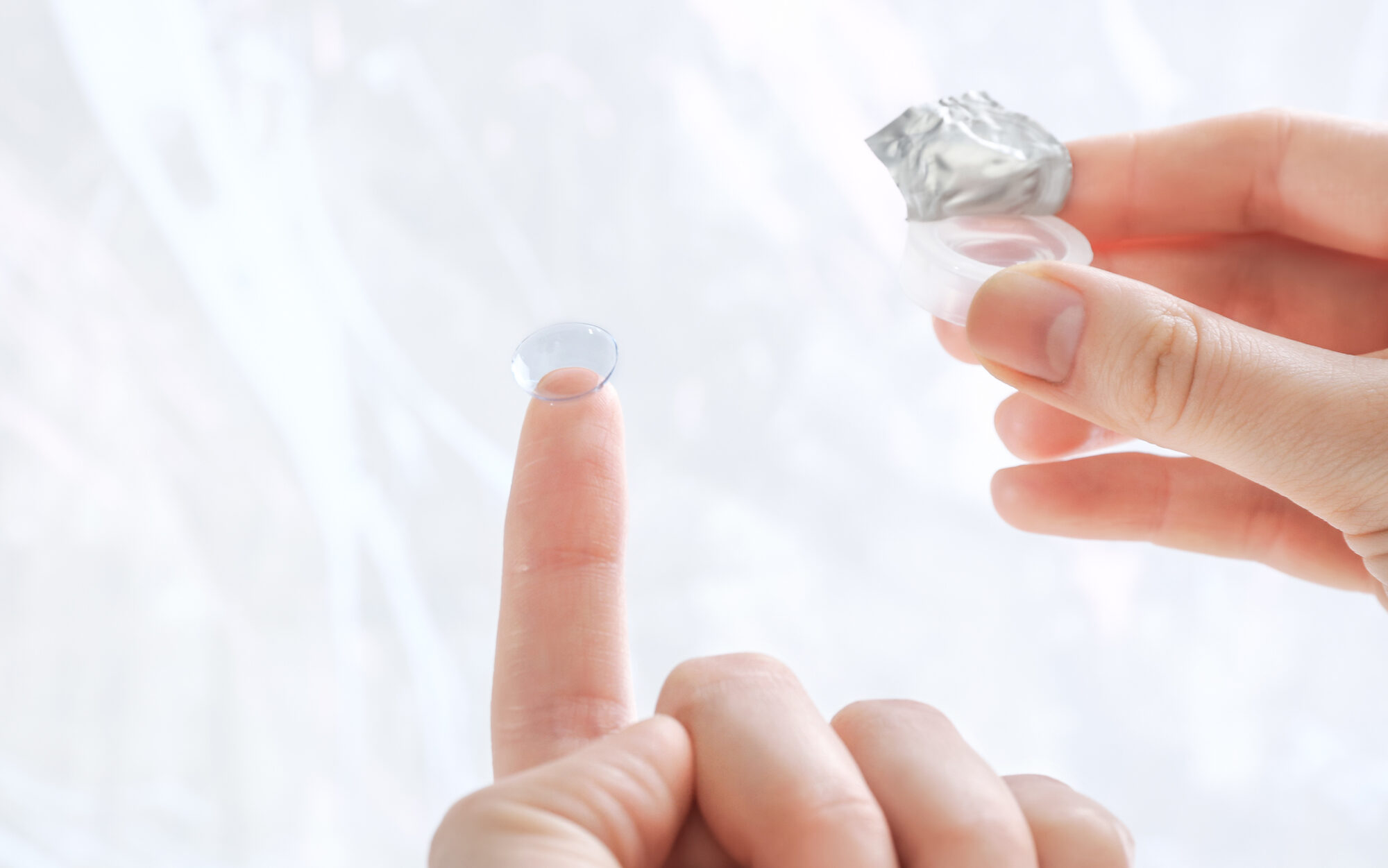 Types of Contacts and Their Expiration Dates 2 Gas permeable contact lenses being held by woman outside of photo edited