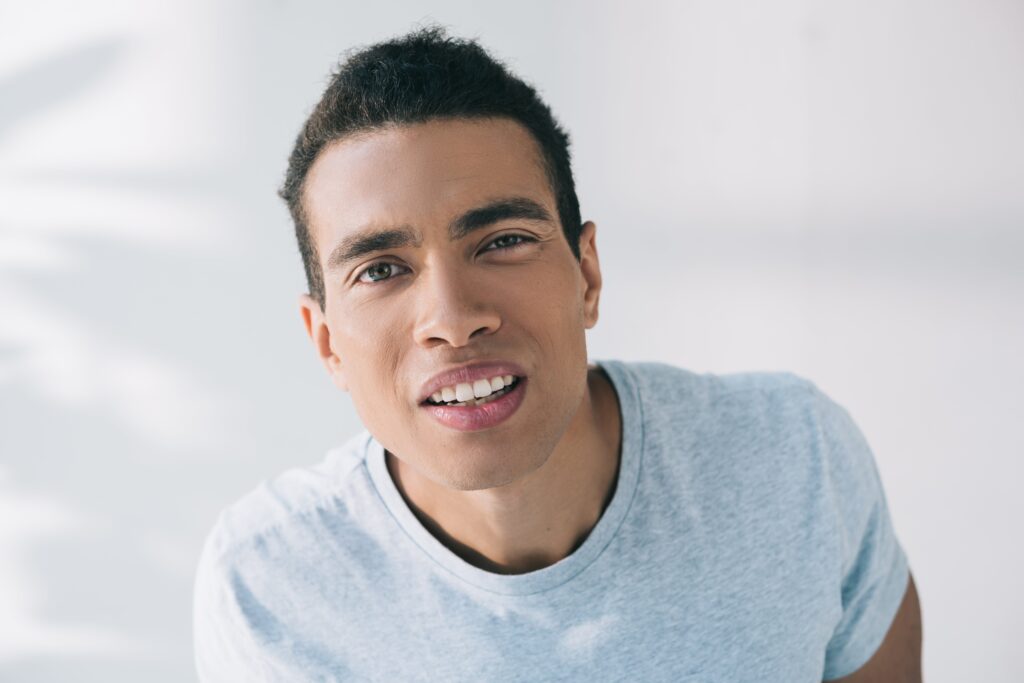 Why Does My Eye Hurt When I Blink? Causes & Treatments 2 Mixed muscular man winking while facing camera