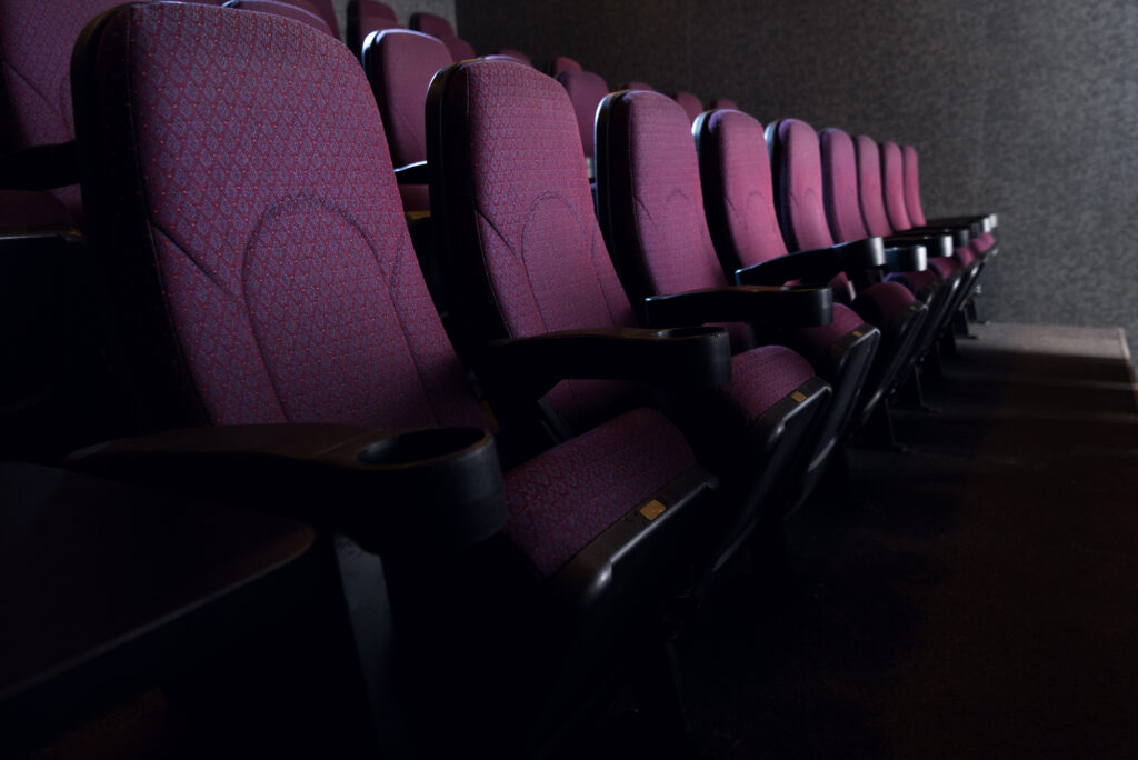 What are the Main Causes of Night Blindness? 2 rows of seats in a movie theater being shown through a dim light