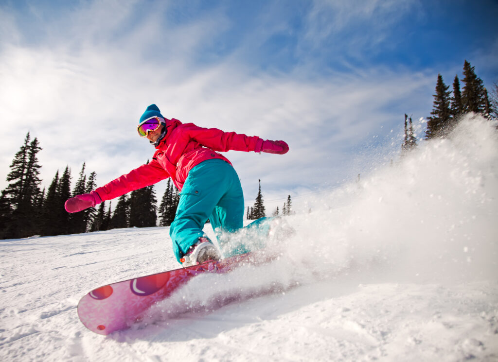 8 Best Ski Goggles When Hitting the Slopes in 2024 26 Snowboarder jumping through air with deep blue sky in background