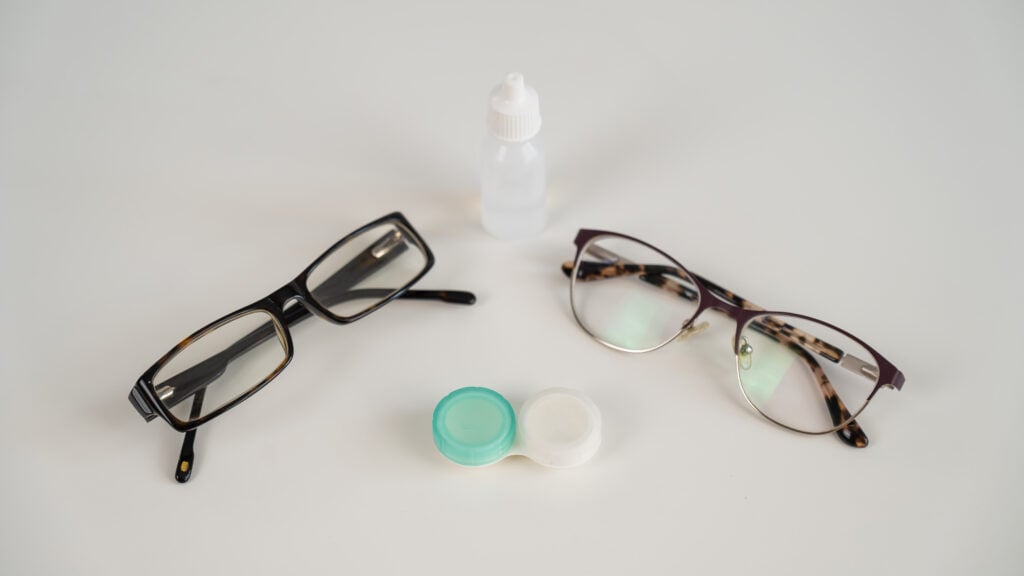 Are Anti-Glare Glasses Worth It? 4 two pairs of glasses lenses and contact drops in the eyes on a white table